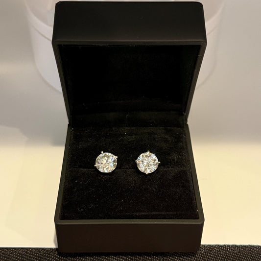 Close-up of 4 carat lab grown diamond stud earrings set in solid 14K gold, round cut, minimalist design on white background.