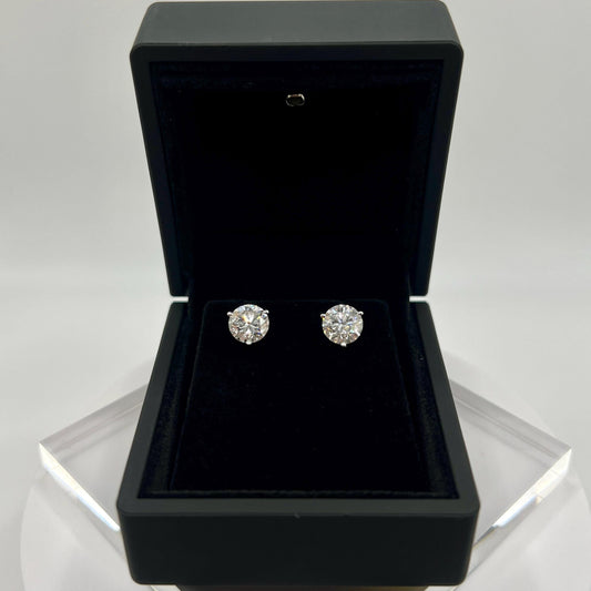 Close-up of 3 carat lab grown diamond stud earrings set in solid 14K gold, round cut, minimalist design on white background.
