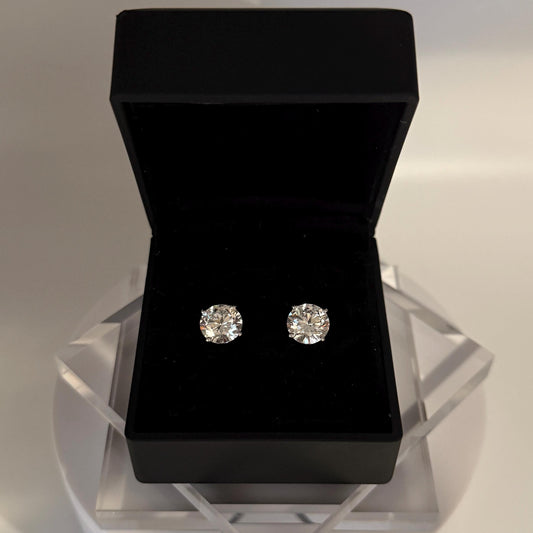 Close-up of 5 carat lab grown diamond stud earrings set in solid 14K gold, round cut, minimalist design on white background.
