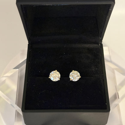 Close-up of 2 carat lab grown diamond stud earrings set in solid 14K gold, round cut, minimalist design on white background.