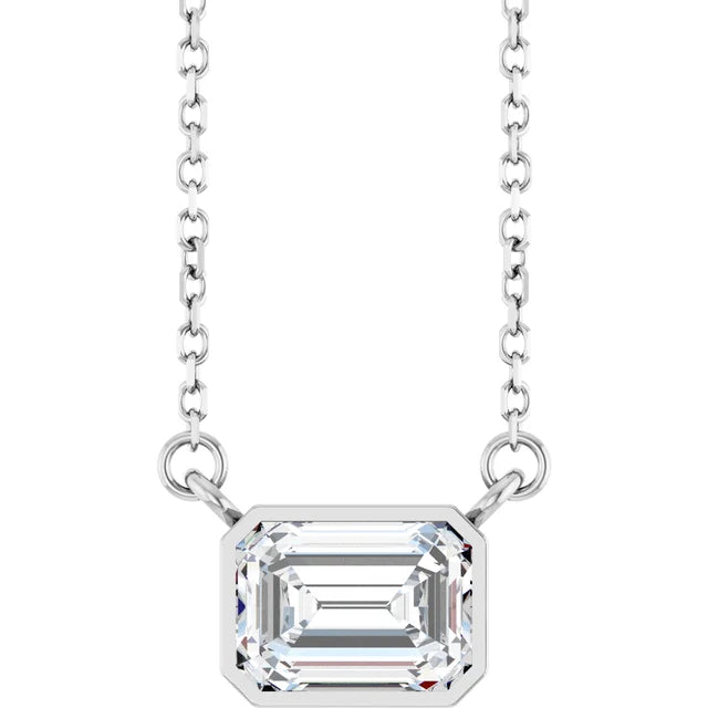 A silver necklace with a large, clear gemstone pendant.