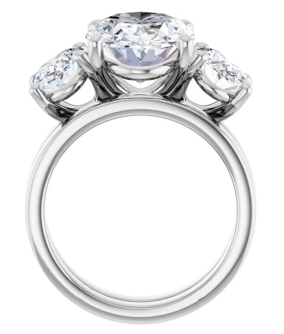 A silver ring with a large central diamond surrounded by smaller diamonds on either side.