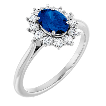 A silver ring with a large oval-shaped blue gemstone surrounded by smaller diamonds.
