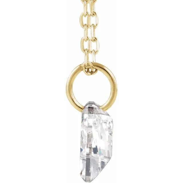 A gold chain necklace with a clear crystal pendant hanging from it.