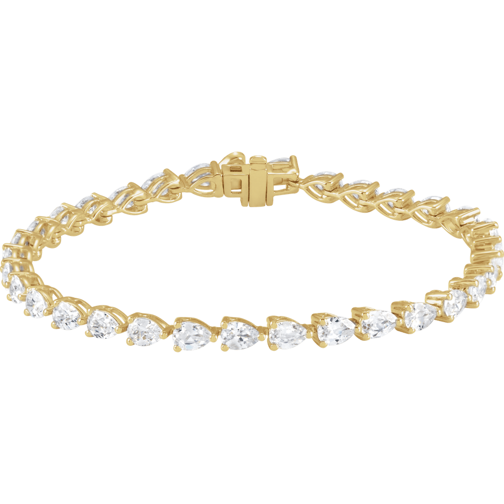 A gold bracelet with a row of small, clear diamonds set in the center.