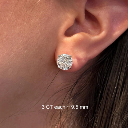 A close-up of a person's ear with a large, clear diamond earring.