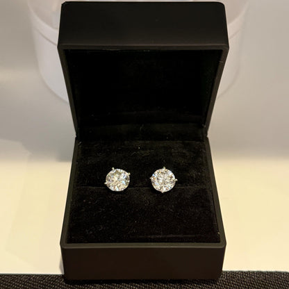 Close-up of 4 carat lab grown diamond stud earrings set in solid 14K gold, round cut, minimalist design on white background.