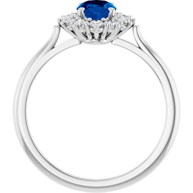 A silver ring with a blue gemstone at the center, surrounded by smaller diamonds.