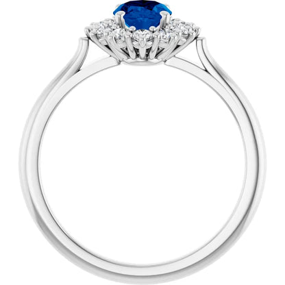 A silver ring with a blue gemstone at the center, surrounded by smaller diamonds.
