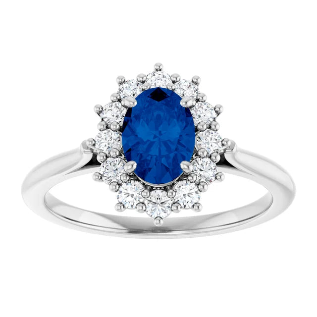 A silver ring with a large oval-shaped blue gemstone surrounded by smaller diamonds.