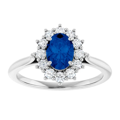 A silver ring with a large oval-shaped blue gemstone surrounded by smaller diamonds.