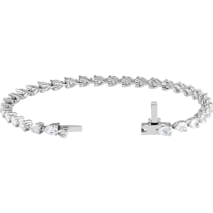 A silver bracelet with a row of small diamonds or pearls on it, set against a dark blue background.
