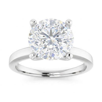 A large, brilliant-cut diamond engagement ring with a silver band.