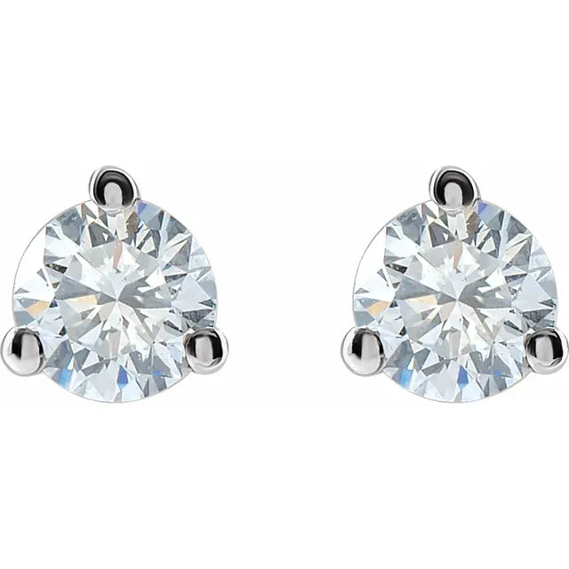 A pair of diamond earrings with a large, clear gemstone set in a silver metal frame.