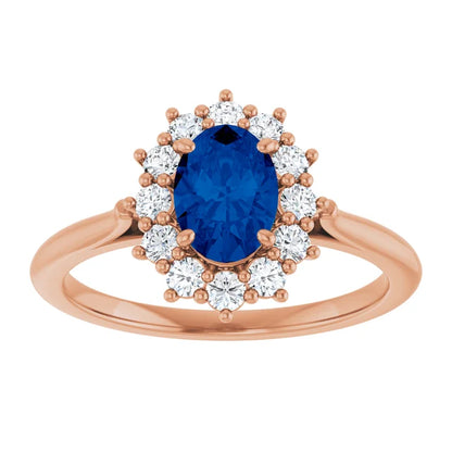A rose gold ring with a large oval-shaped blue gemstone surrounded by smaller diamonds.