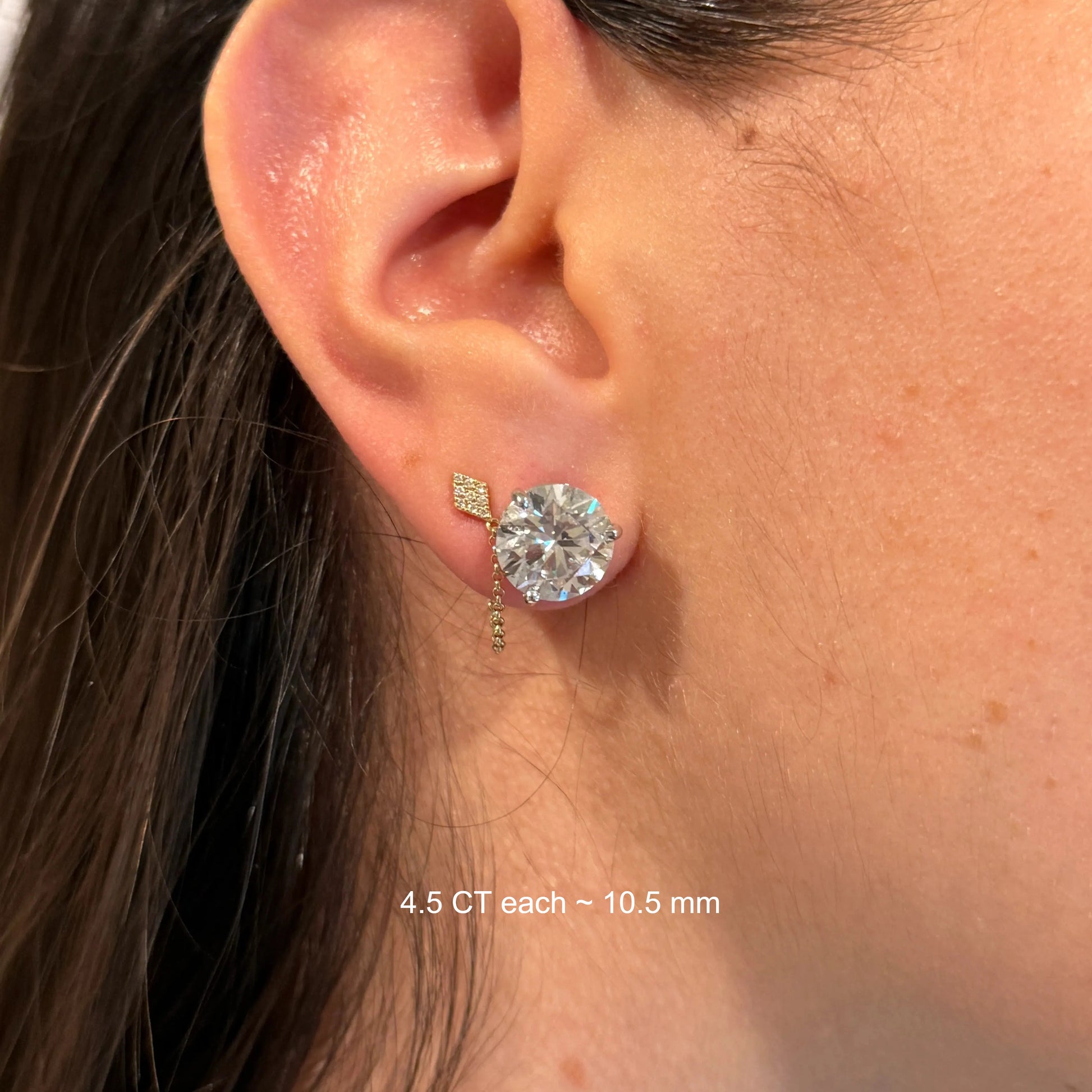 A close-up view of a person's ear adorned with a large, sparkling diamond earring.