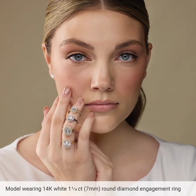 A woman wearing a 14K white 1/4ct (7mm) round diamond engagement ring is shown in the image.
