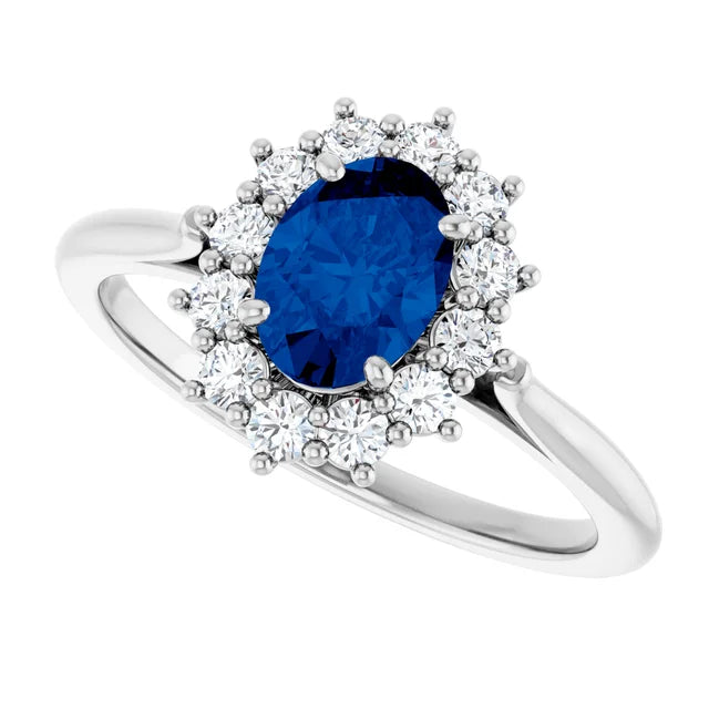 A silver ring with a large blue gemstone at the center, surrounded by smaller diamonds.