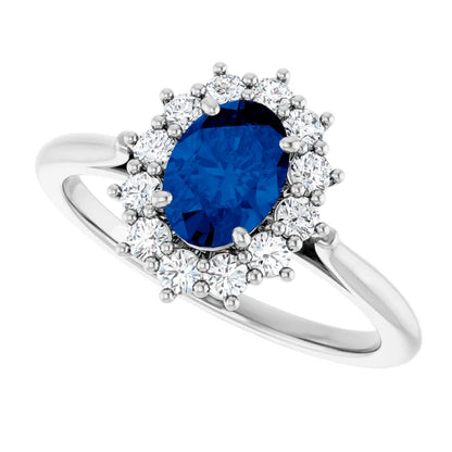 A silver ring with a large blue gemstone at the center, surrounded by smaller diamonds.