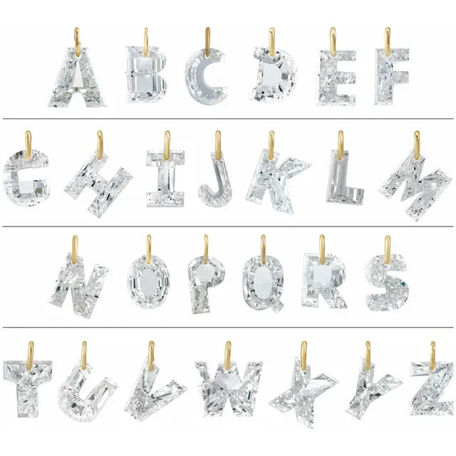 a collection of letters of the alphabet, each made of a clear crystal material, such as diamonds or other precious stones. The letters are suspended from gold chains, creating a visually striking and elegant display.