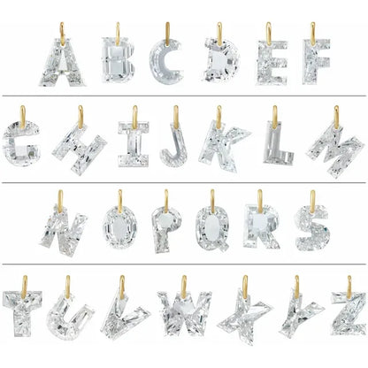 a collection of letters of the alphabet, each made of a clear crystal material, such as diamonds or other precious stones. The letters are suspended from gold chains, creating a visually striking and elegant display.