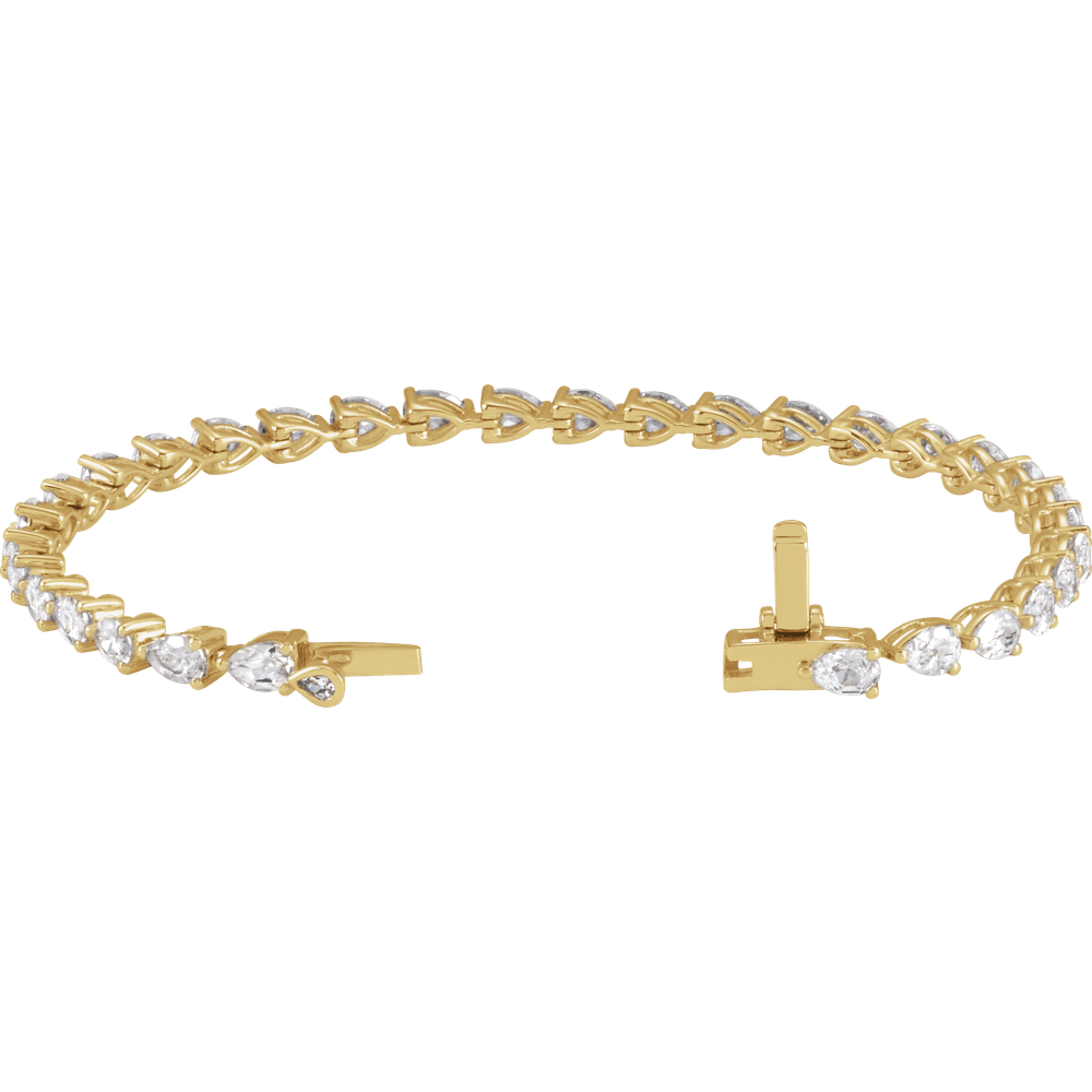 A gold bracelet with a row of small diamonds on it.